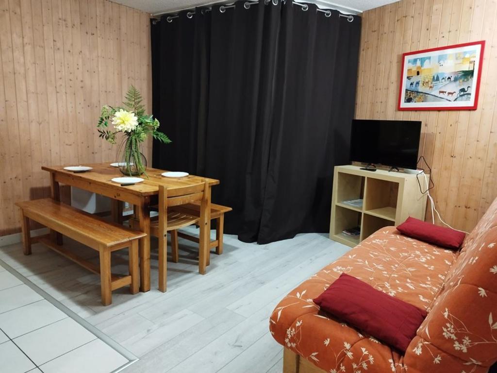 un salon avec une table et un canapé dans l'établissement Appartement lumineux 8 pers, pied des pistes, 2 ch, balcon, cuisine équipée, proche commerces et sports - FR-1-262-91, à Forest des Baniols