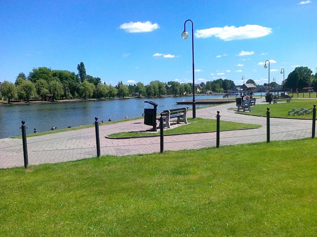 een park met een rivier en een straatlicht en banken bij Apartament Augustów in Augustów