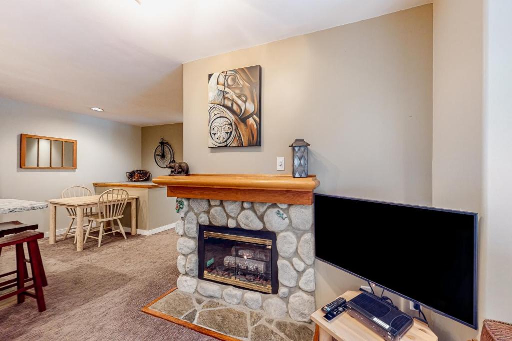 uma sala de estar com lareira e televisão de ecrã plano em Lake Placid Coach House 17 em Whistler