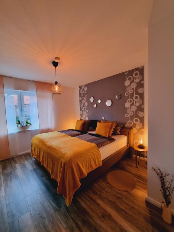 a bedroom with a large bed with an orange blanket at Haus Moor Merland in Moormerland