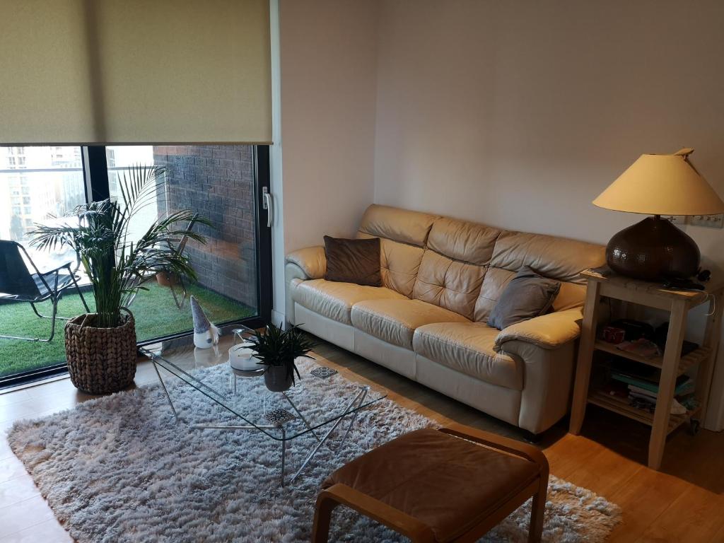 a living room with a couch and a glass table at Entire Flat - Modern Flat near Canary Wharf in London