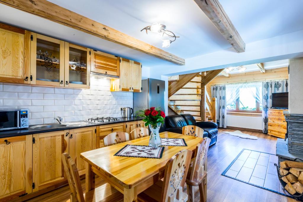 una cucina e una sala da pranzo con tavolo in legno di Domek u Wawrytki a Zakopane
