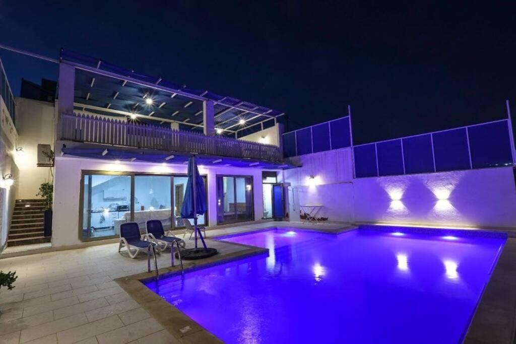 安曼的住宿－Aqua Blue Villa-Dead Sea, Jordan，一座晚上设有游泳池的房子