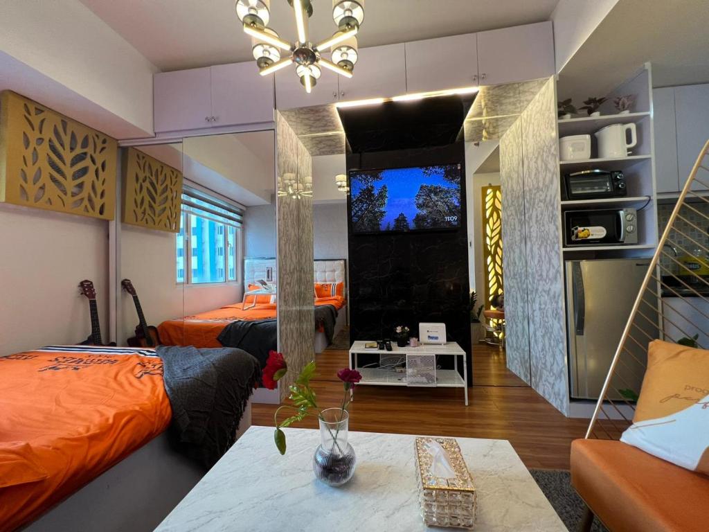 um quarto com duas camas e uma mesa num quarto em Cozy studio unit at Sun Residences em Manila