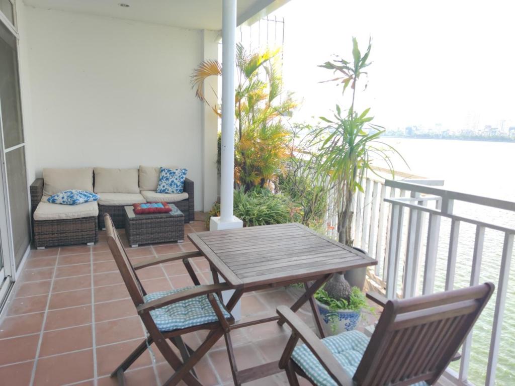 a porch with a table and chairs and a couch at Davidduc's Apartment Quang Khanh in Hanoi