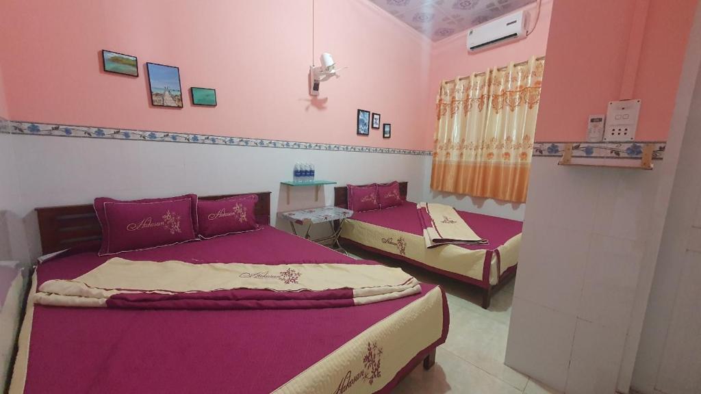 2 Betten in einem Zimmer mit rosa Wänden in der Unterkunft Homestay Nam Du Xanh in Nam Du