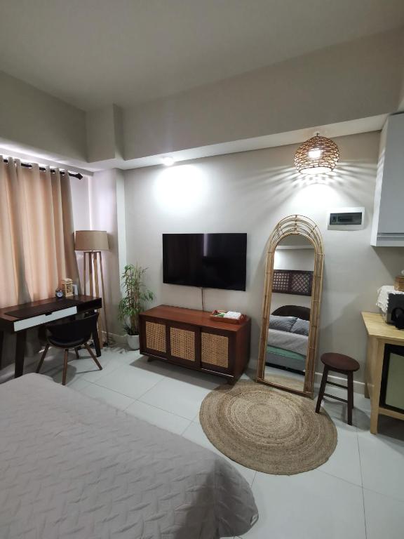 a bedroom with a bed and a flat screen tv at Baseline Premier - Studio with mountain view in Cebu City