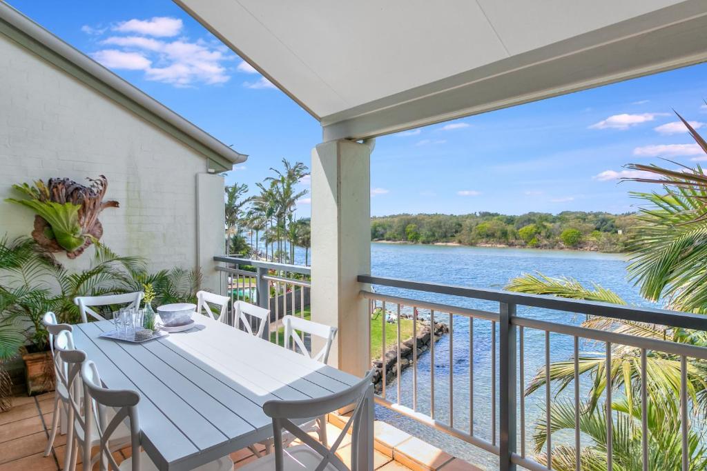 a balcony with a table and chairs and a view of the water at Sunrise Cove- 2BR Waterfront Apartment by uHoliday in Kingscliff