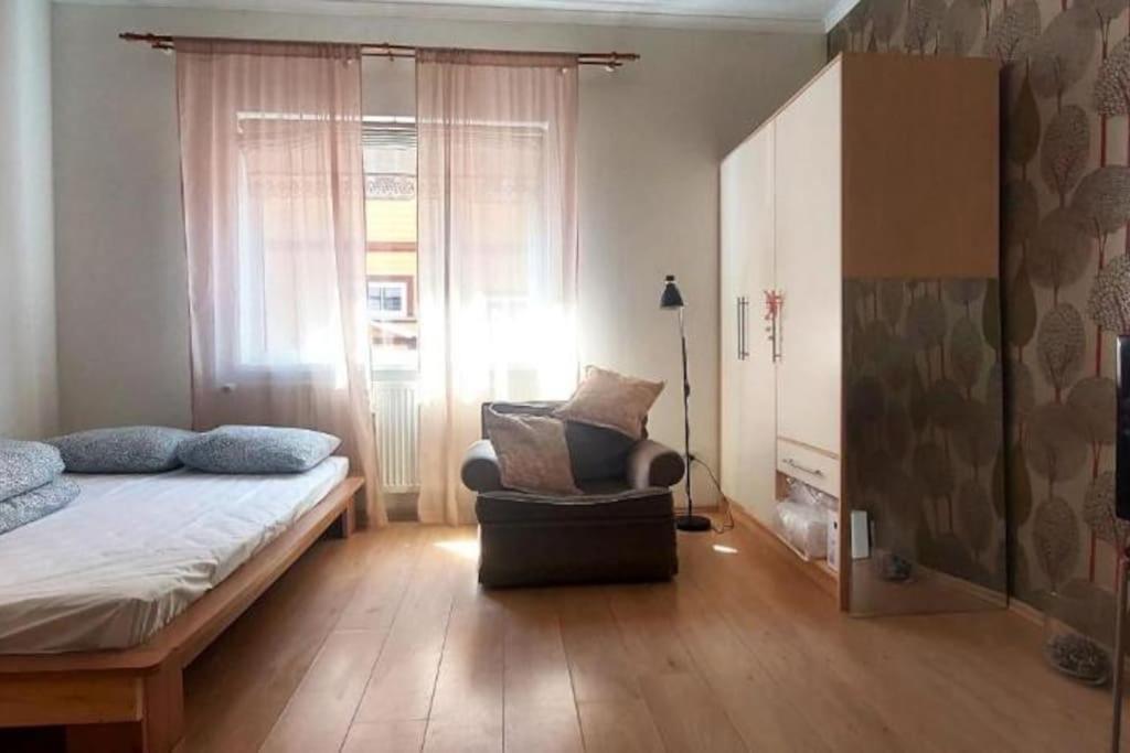 een slaapkamer met een bed, een stoel en een raam bij Lossikamber Kalamajas in Tallinn