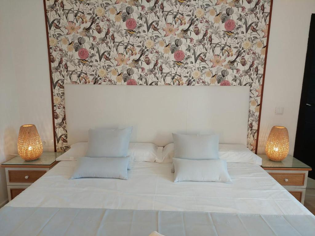 a bedroom with a large bed with a floral headboard at Hostal GARDEN ROUS in Paiporta
