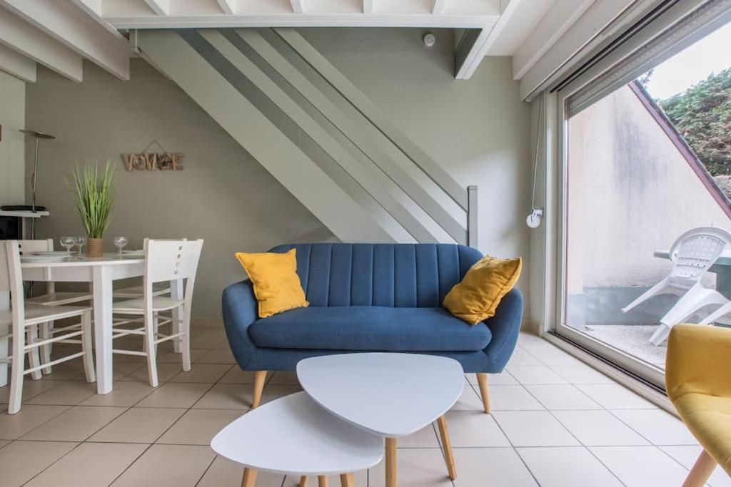 un soggiorno con un divano blu e un tavolo di Cottage Opale a Stella-Plage