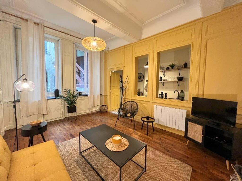 a living room with a couch and a table at Le boudoir de Clem in Chalon-sur-Saône