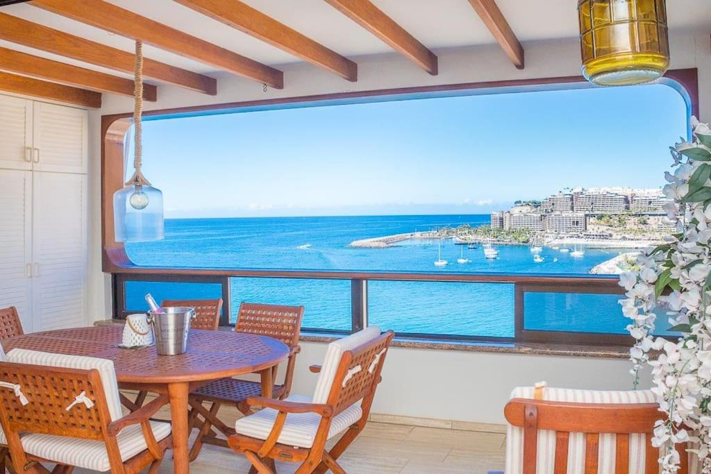 een balkon met een tafel en stoelen en uitzicht op de oceaan bij 100 m2 Penthouse on the beach. in Patalavaca