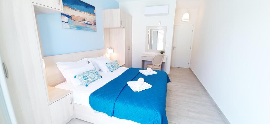 a small bedroom with a blue and white bed at The Central Villa - Kassiopi Corfu Villas in Kassiopi