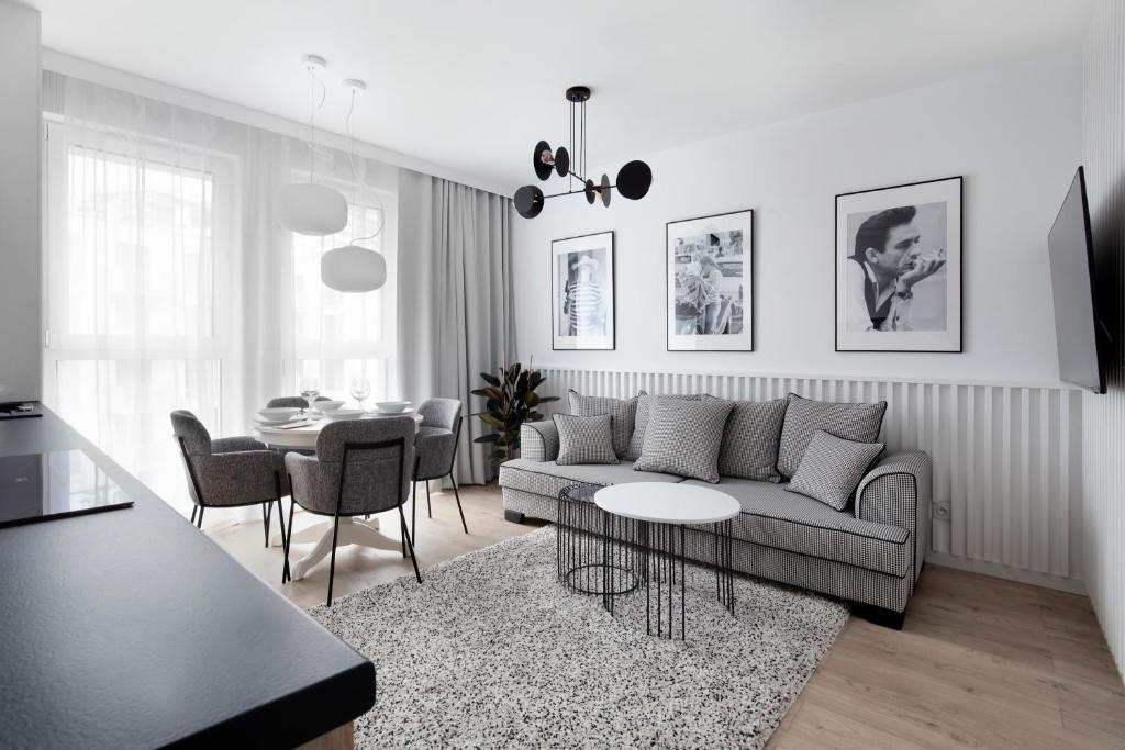 a living room with a couch and a table at Aura 40 City Center by Downtown Apartments in Gdańsk