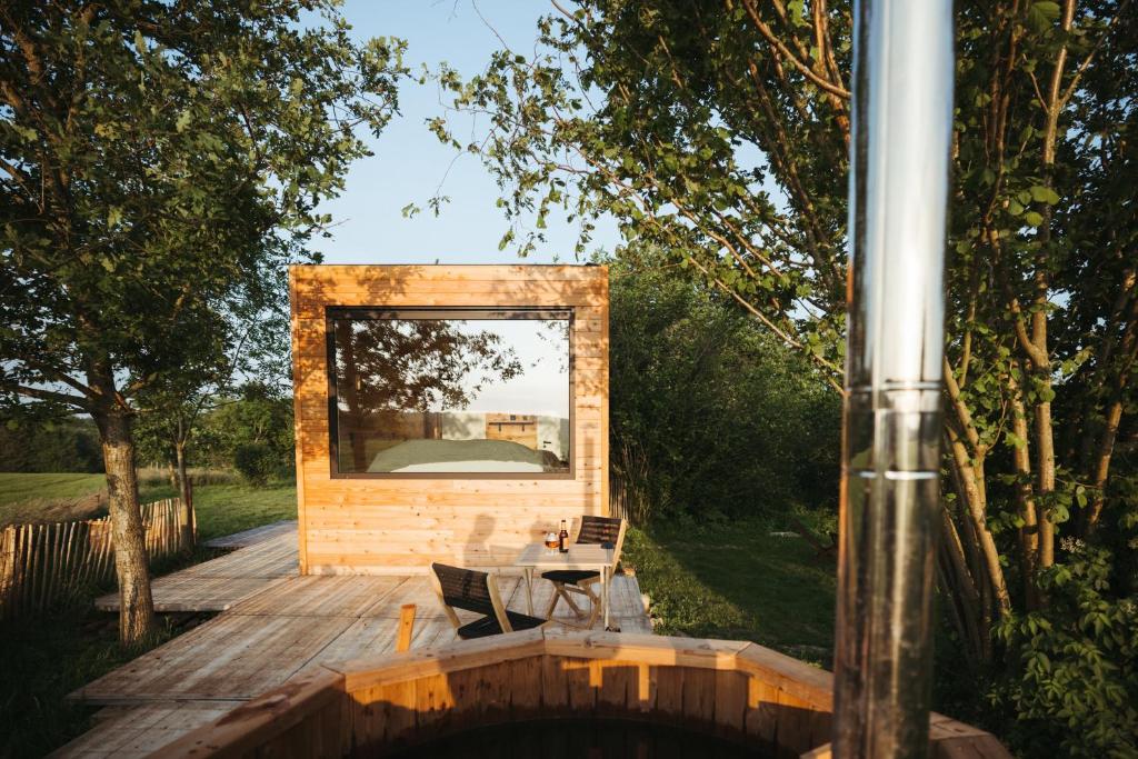 una casa con un espejo en una terraza de madera en La cabane de la Ferme du Ry, en Sorinnes