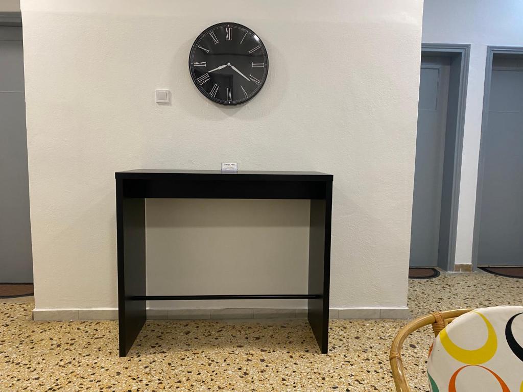 a black fireplace with a clock on a wall at Sunset view Rooms in Agia Triada