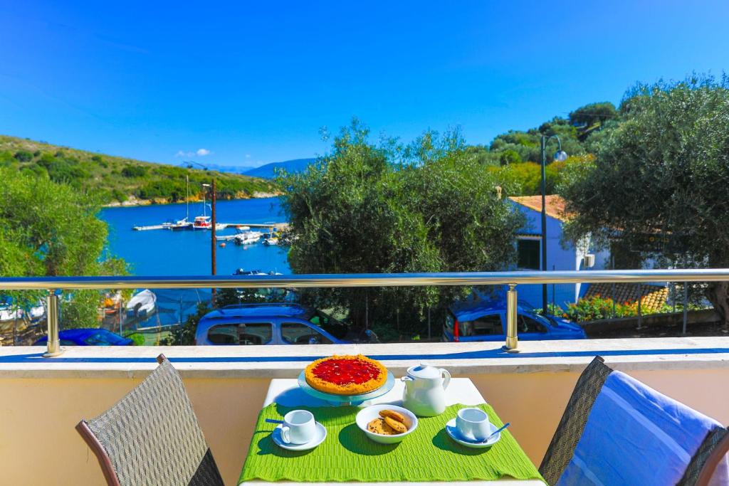 una mesa con un plato de comida en la parte superior de un balcón en Theophilos Ena, en Ágios Stéfanos
