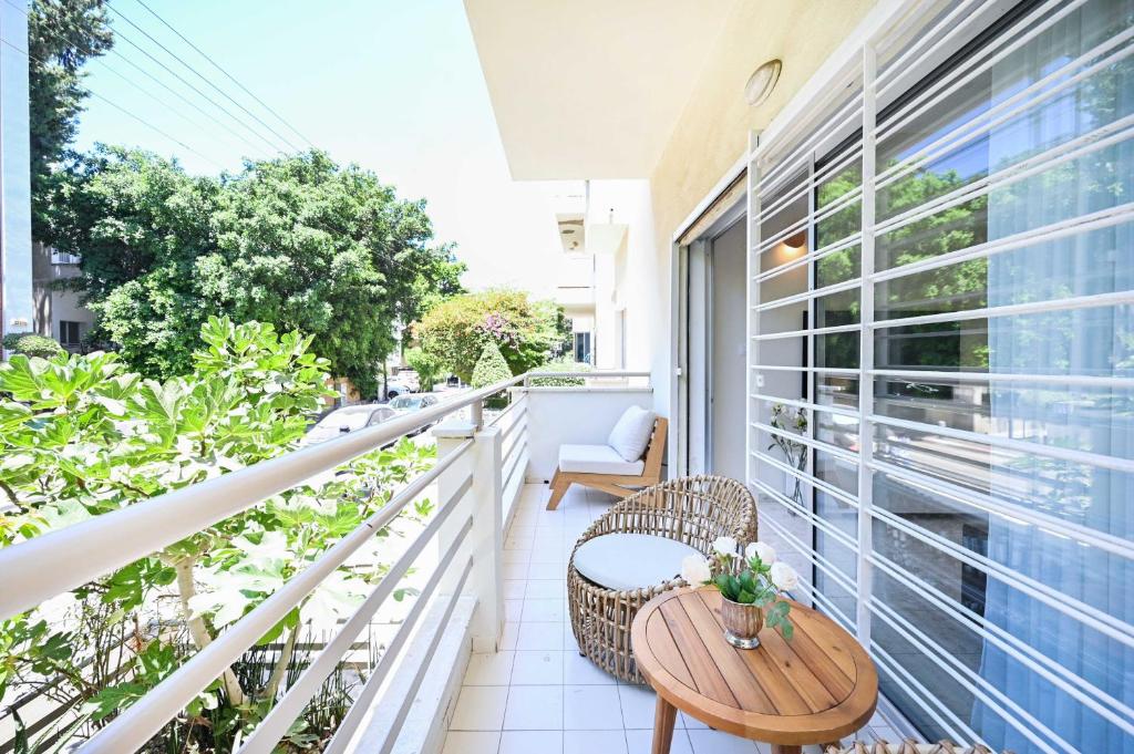 Apartamento con balcón con mesa y sillas de madera. en Friendly 2BR in Gordon area by HolyGuest, en Tel Aviv