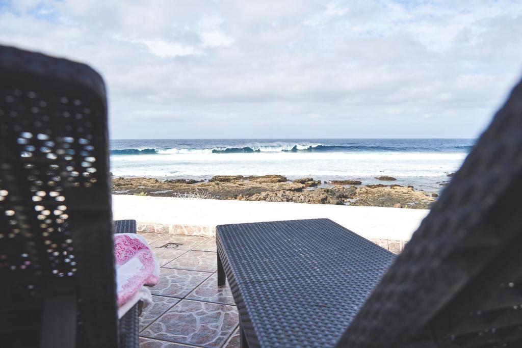 a table and chairs on the beach with the ocean at Casa Mar adentro in La Santa