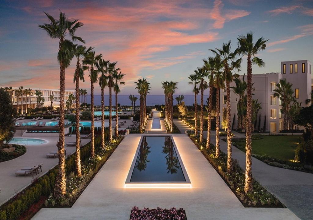 a resort with a pool with palm trees and lights at Ikos Andalusia in Estepona