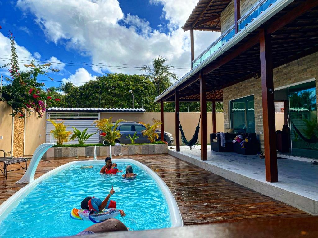 zwei Personen in einem Schwimmbad in einem Haus in der Unterkunft Casas Peroba Maragogi in Maragogi