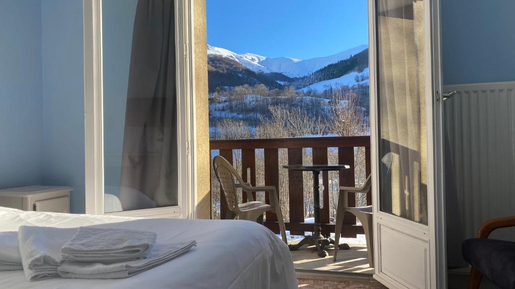 a bedroom with a bed and a balcony with a view at Le Brunet in Saint-Jacques-des-Blats