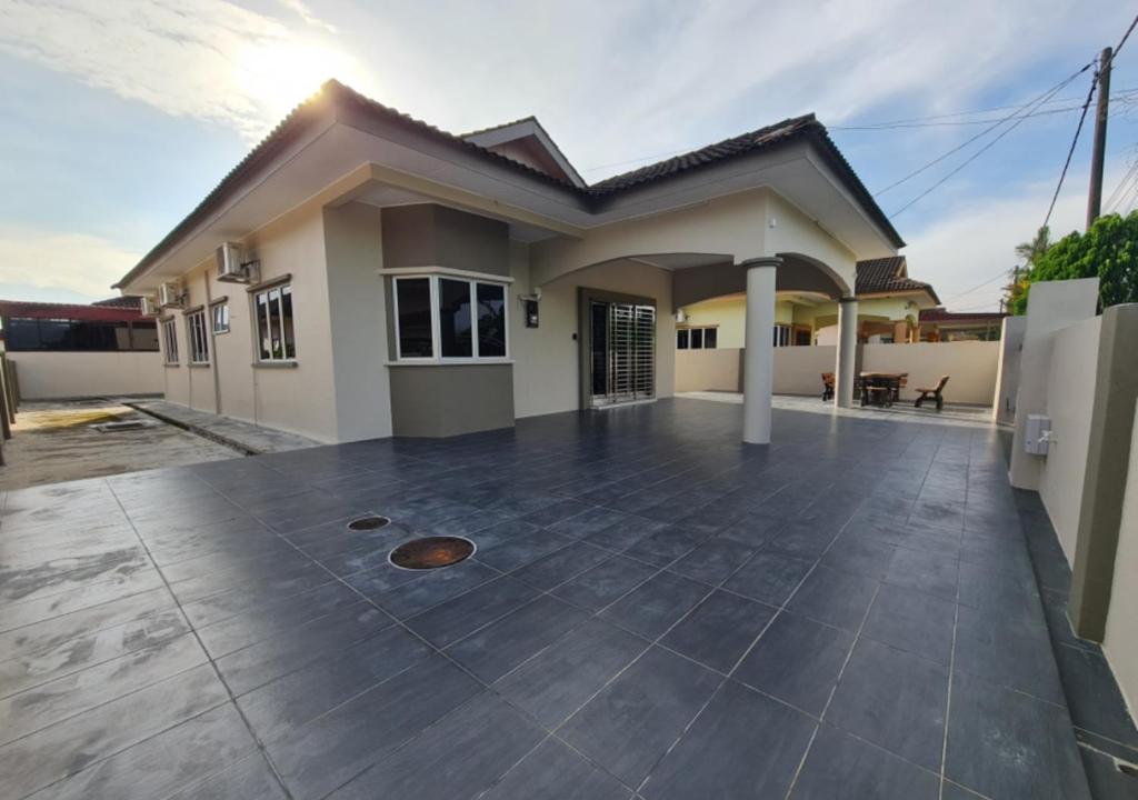 ein kleines Haus mit einer großen Terrasse in der Unterkunft Air-home No 9 Kampung Boyan, 4BR, 9pax, Netflix in Taiping