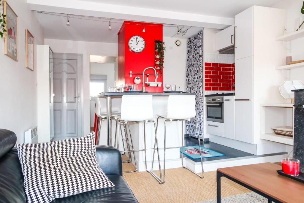 une cuisine avec un bar et un mur rouge dans l'établissement Le Duomo - Duplex avec vue sur le Dôme de la Grave, à Toulouse