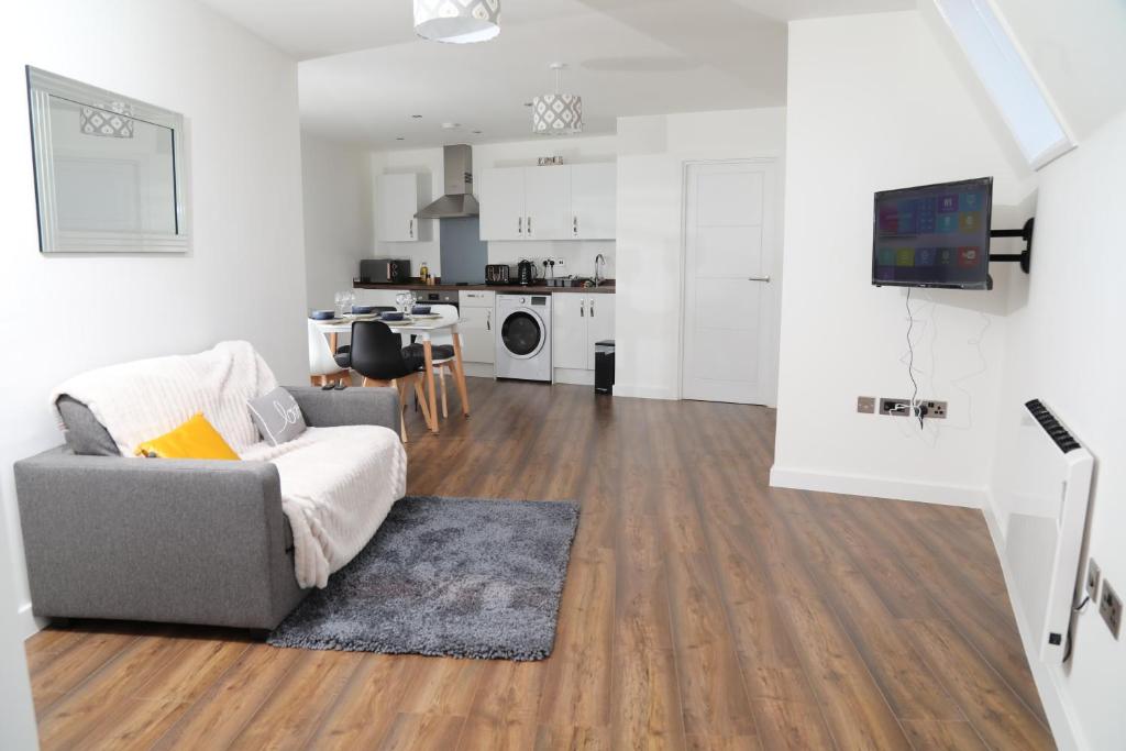 a living room with a couch and a kitchen at Plush 2-bedroom apartment Coventry city center in Coventry