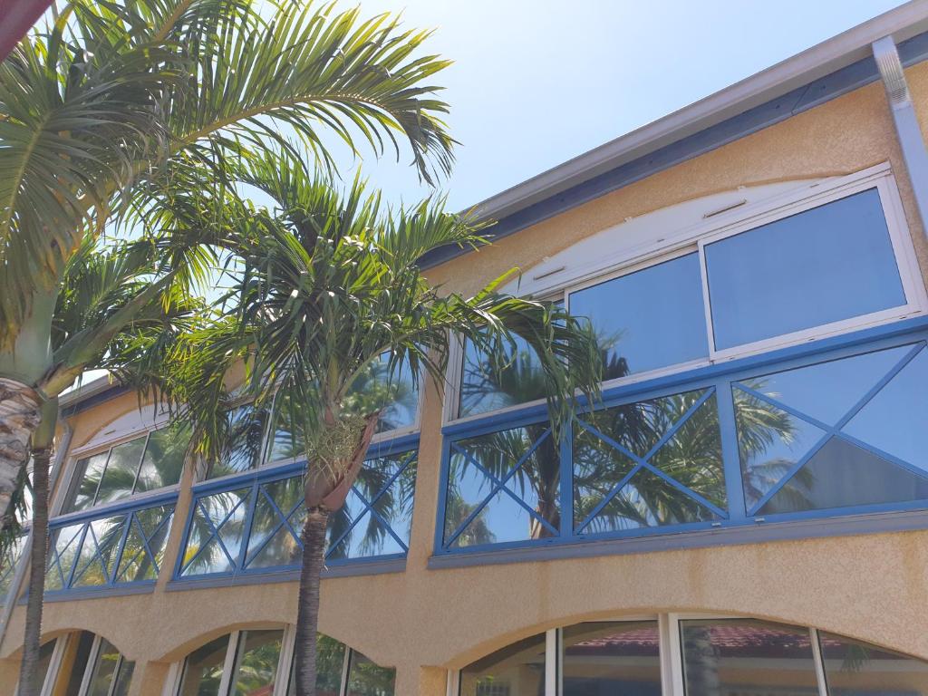 a building with palm trees in front of it at Aquabeach in La Saline les Bains