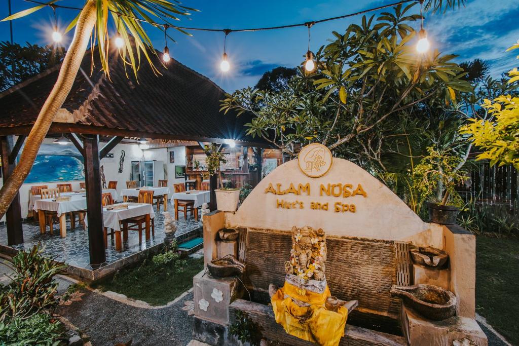a restaurant with a grill in front of the ocean at Alam Nusa Bungalow Huts & Spa in Nusa Lembongan
