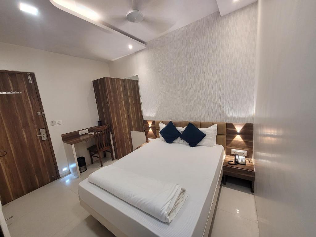 a bedroom with a white bed and a piano at Hotel Heritage - Near Trade Center, Visa Consulate BKC in Mumbai