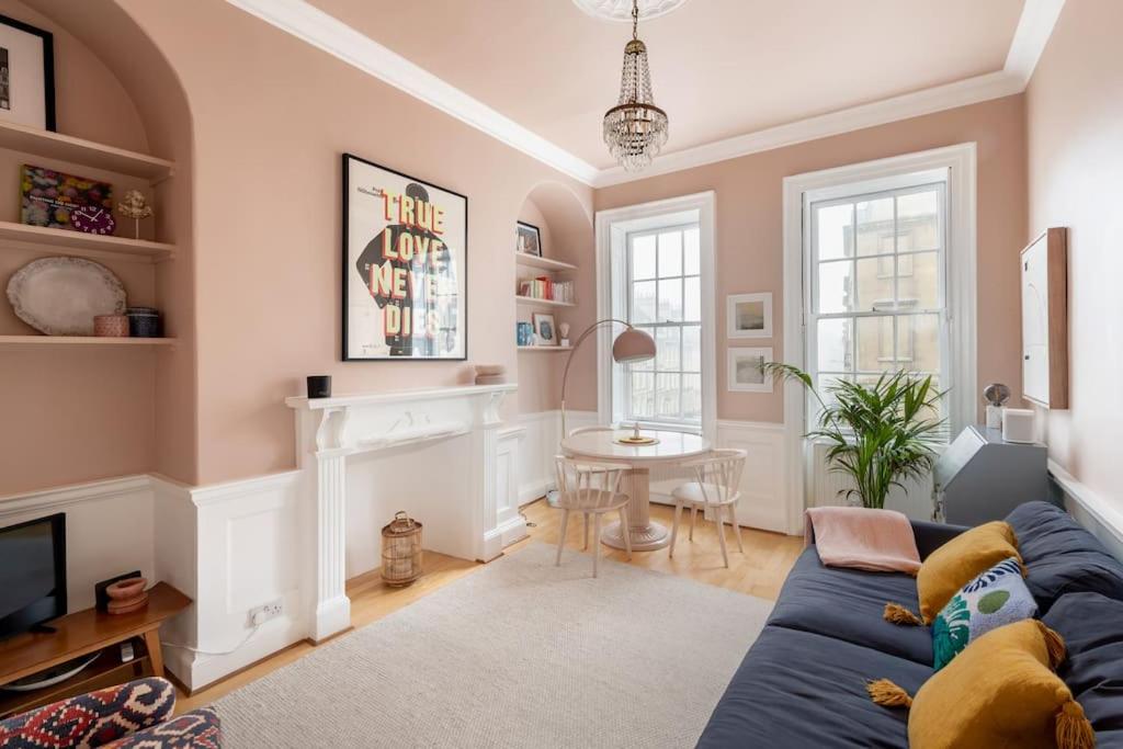 a living room with a blue couch and a table at Stylish Central Apartment with Parking - Garden and Workspace in Bath