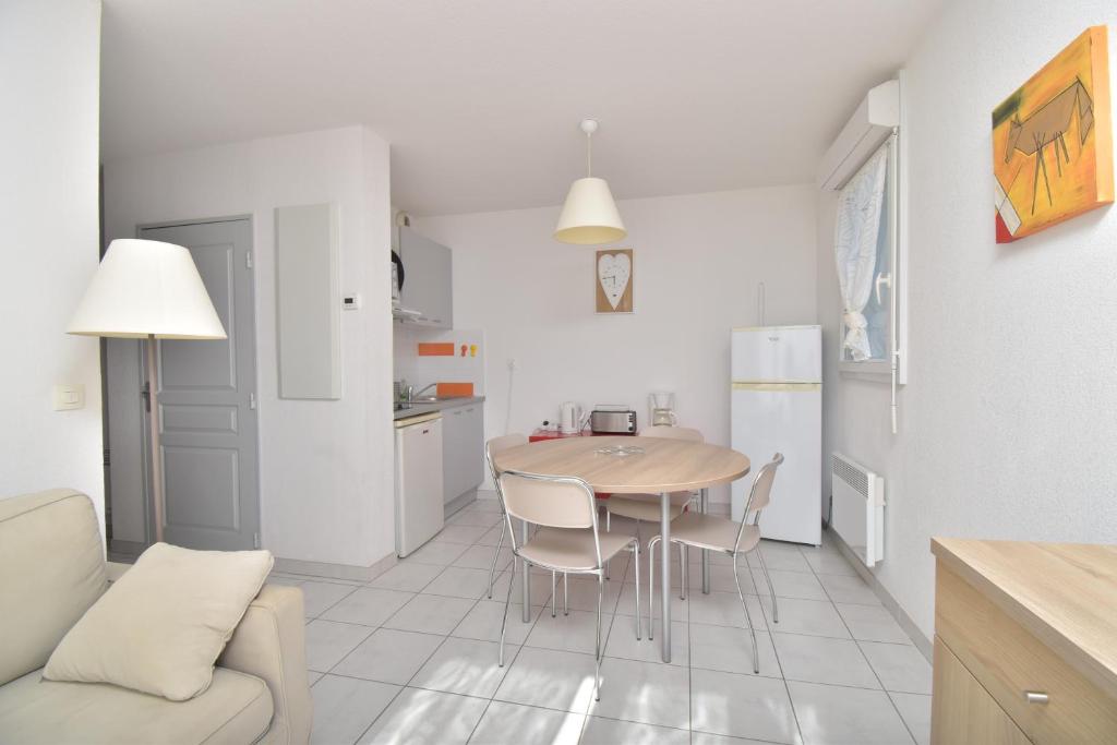 a kitchen and living room with a table and chairs at T2 Résidence Cap Camargue avec piscine in Le Grau-du-Roi