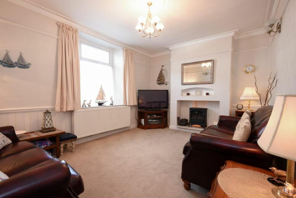 a living room with a couch and a tv at Seaview Cottage Amble in Amble
