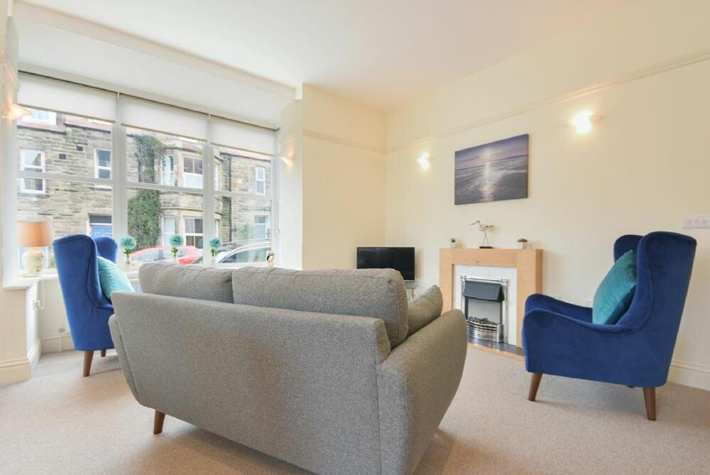 sala de estar con sofá y 2 sillas azules en St Julians, en Alnmouth