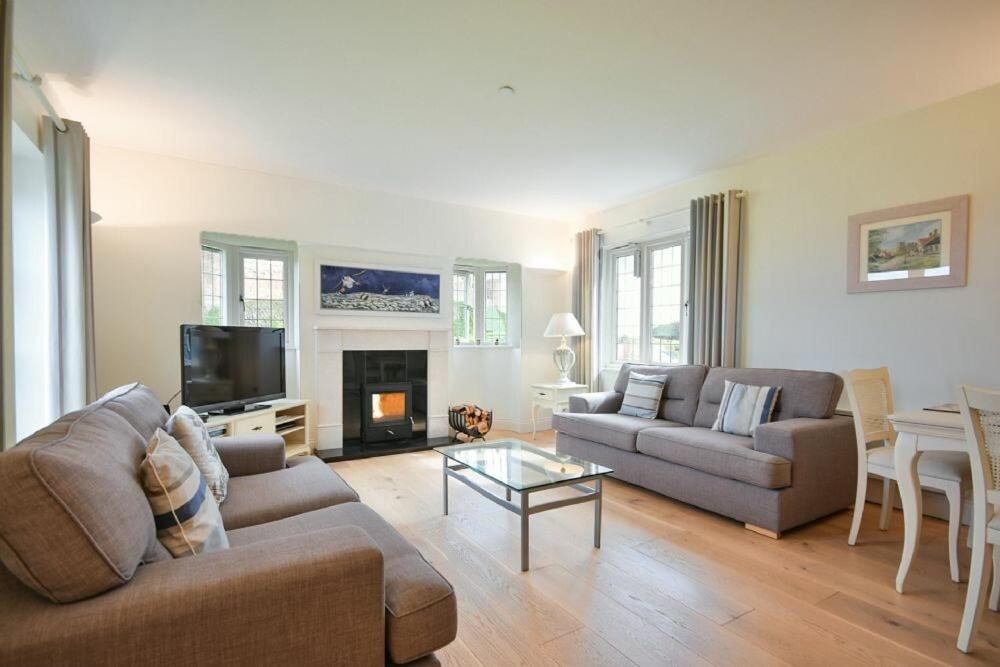 a living room with two couches and a fireplace at Two Castles in Bamburgh