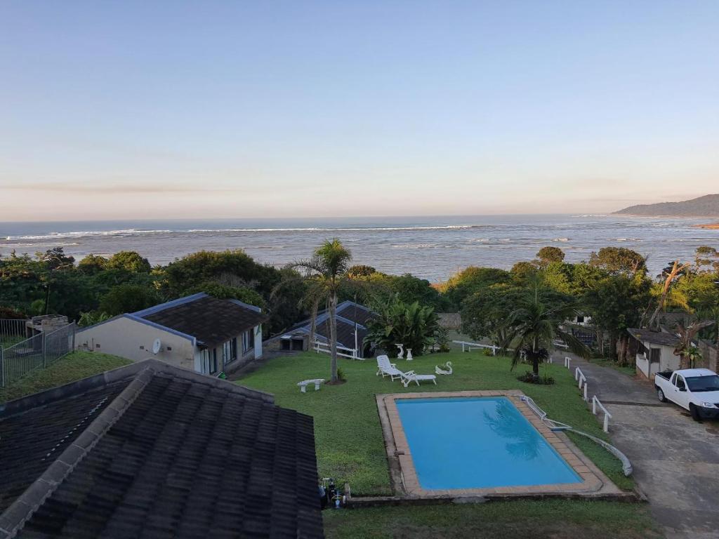a view of a swimming pool and the ocean at Driftwood Chalets in Tugela Mouth