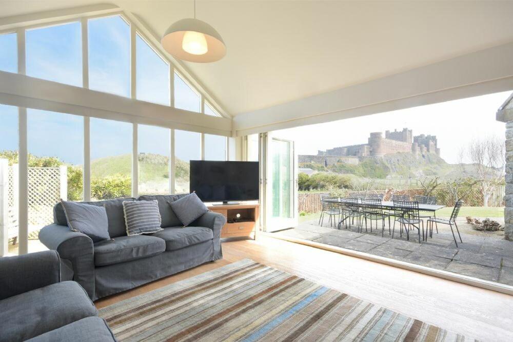 a living room with a couch and a large window at The Wynd in Bamburgh