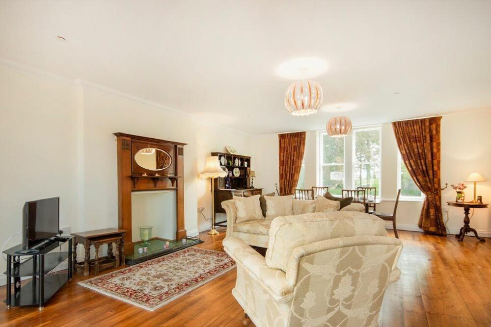 a living room with a couch and a tv at The Old Concert Room in Alnmouth