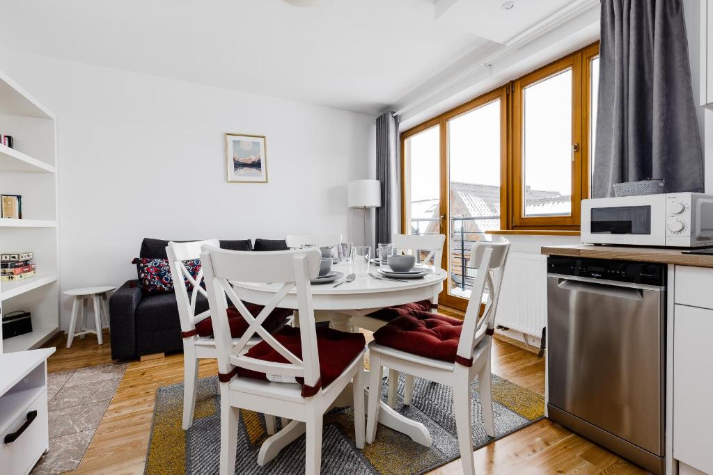 a kitchen and dining room with a table and chairs at RentPlanet - Apartamenty Krzeptówki in Zakopane