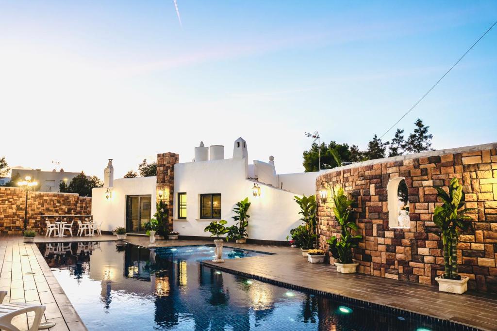 una casa con piscina al lado de un edificio en Ocean Suites, en Bahía de San Antonio