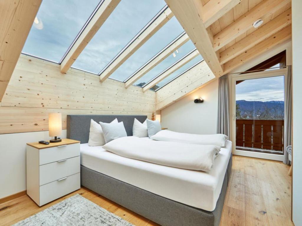 a bedroom with a large white bed with a window at Fewo Sterntaler DG mit Bergblick in Garmisch-Partenkirchen