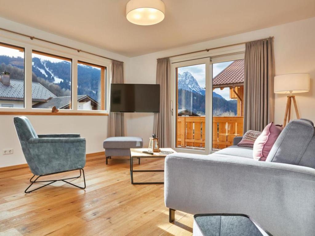 sala de estar con sofá, sillas y ventanas en Fewo Sterntaler OG in Garmisch-Partenkirchen en Garmisch-Partenkirchen