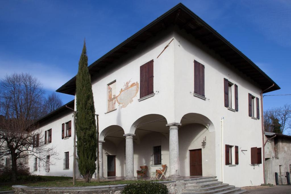 un bâtiment blanc avec un arbre devant lui dans l'établissement B&B Villa Natta, à Uggiate