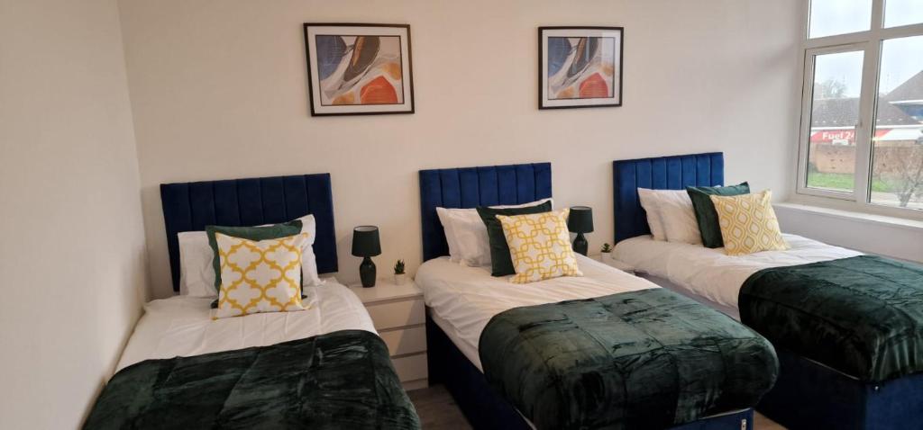 a room with three beds with pillows on them at Flitwick Luxury Apartment - Sleeps 4 in Flitwick