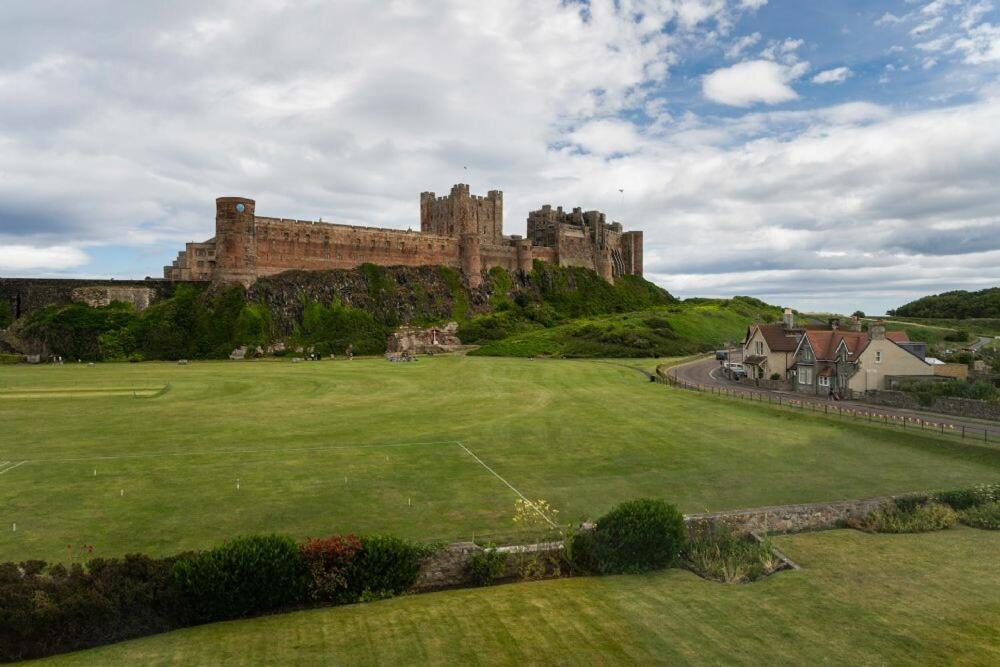 a large castle on top of a green field at Keeper's View in Bamburgh