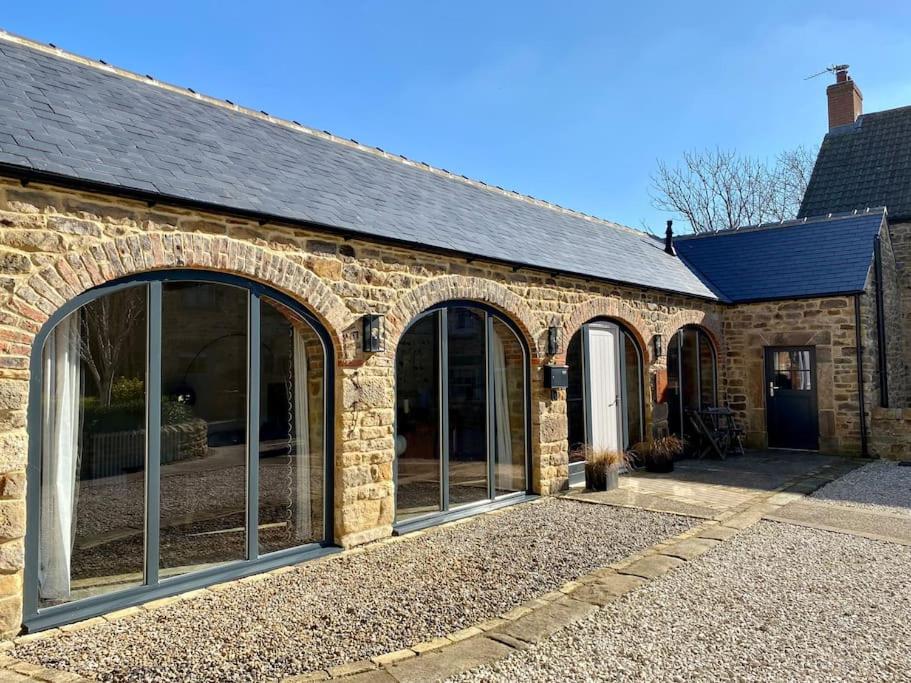 ダラムにあるContemporary Luxury Barn Conversion in County Durhamの大きなガラス窓のあるレンガ造りの建物