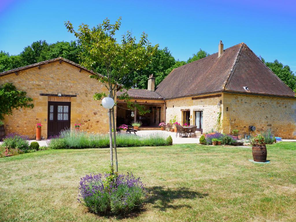 a large stone house with a yard with a garden at Le Nid de Faucons in Lalinde